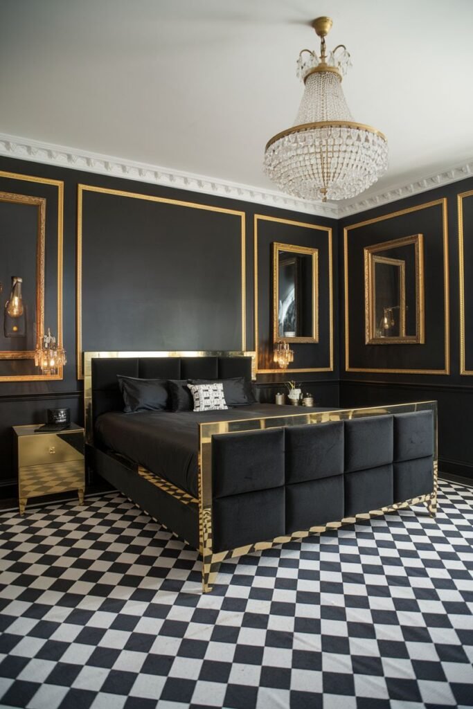 A graphic black bedroom with dark walls framed by gold molding and geometric wall sconces. The bed has a square tufted headboard and a gold frame, dressed in black bedding. The floor features a bold black and white checkerboard pattern. A crystal chandelier hangs from the ceiling.